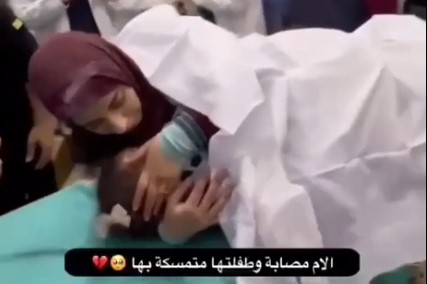 فلسطينية مصابة، ورغم وجعها بقيت محتضنة طفلتها